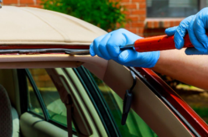 Technician repairing a car windshield at Heart City Toyota Collision Center.